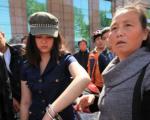 女青年为救人助人，向执勤民警求助无果后，因用脚踢警车来宣泄愤怒而遭警察以手铐铐住